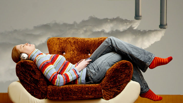 Una ragazza si rilassa sul divano, sullo sfondo dei tubi di scarico.